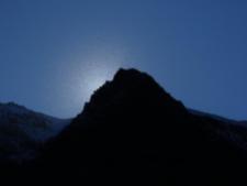 Kurz verschwindet die Sonne hinter einer Bergspitze und die vielen Fireweedsamen in der Luft werden sichtbar.